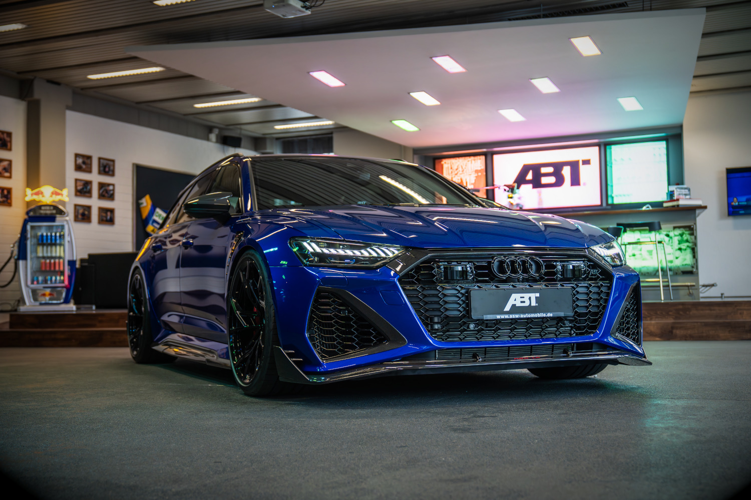 blauer RS6-LE aus der seitlichen Frontansicht im Showroom vor einer Bar 